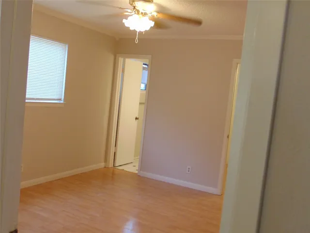 an empty room with a chandelier fan and a bathroom