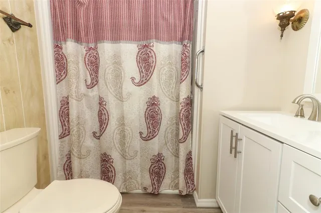 a bathroom with a toilet sink and shower curtain
