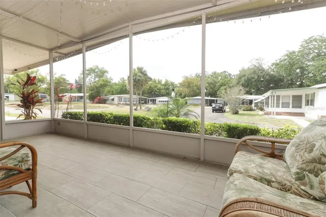 a view of a porch with furniture and floor to ceiling window