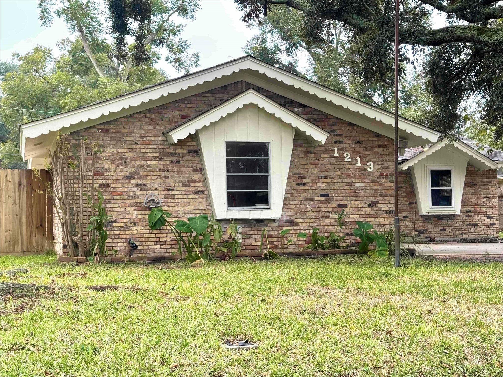 a brick house with a small yard and plants