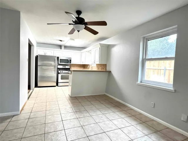 a kitchen with stainless steel appliances kitchen island granite countertop a refrigerator and microwave