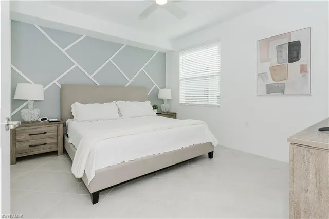 a large bed sitting in a bedroom next to a window with a dresser