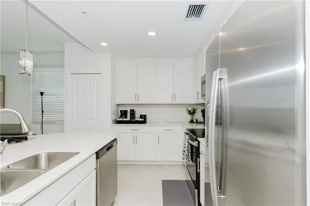 a kitchen with kitchen island a sink appliances and cabinets