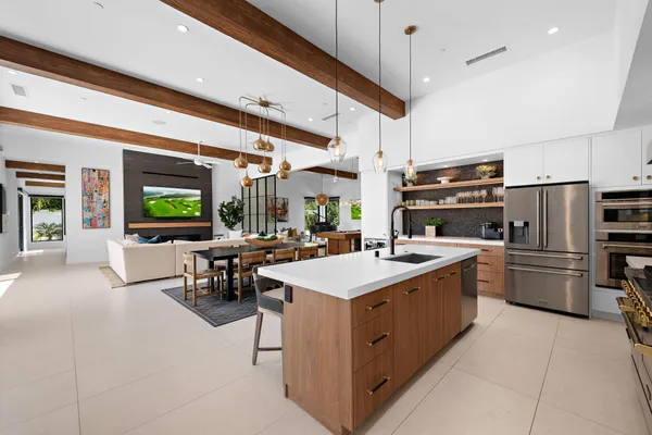 a kitchen with a sink a counter top space stainless steel appliances and a chandelier