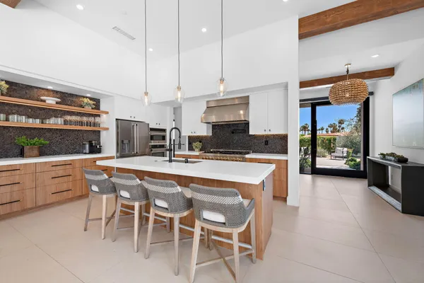 a kitchen with stainless steel appliances kitchen island granite countertop a table and chairs in it