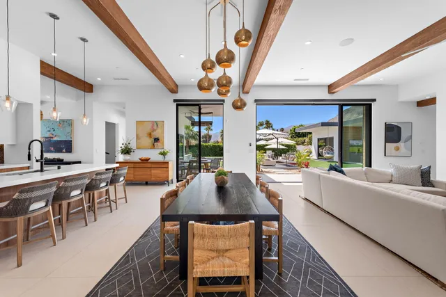 a living room with furniture a dining table and chairs with wooden floor