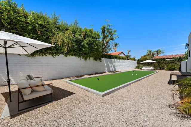 a view of a backyard with couches and swimming pool
