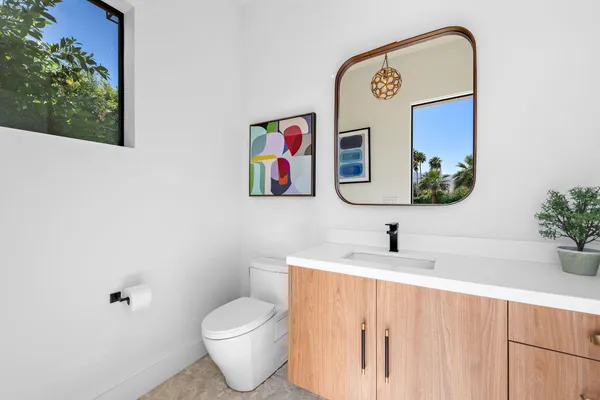 a bathroom with a toilet sink and mirror