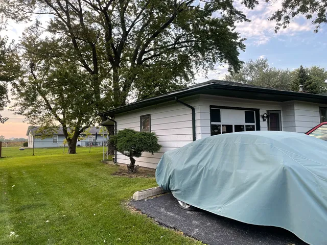 a view of a house with backyard and a tree