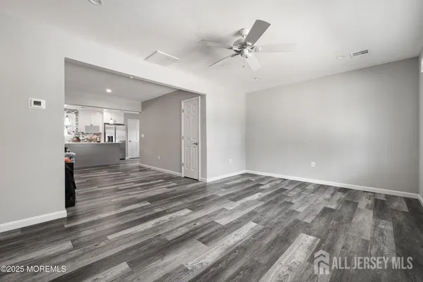 a view of an empty room and a kitchen