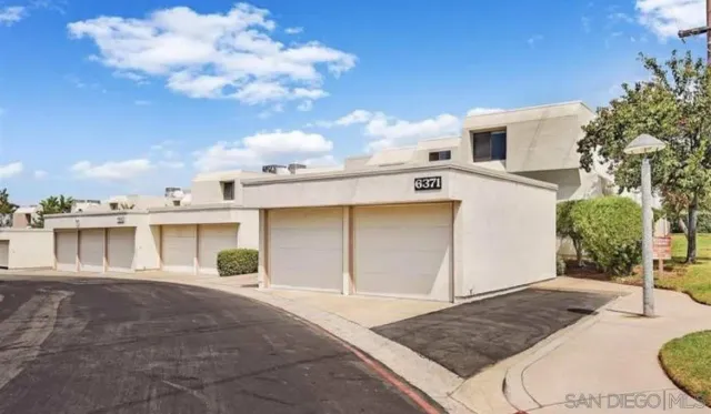 a view of a white house with a yard