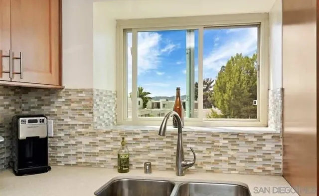 a bathroom with a granite countertop sink and a window