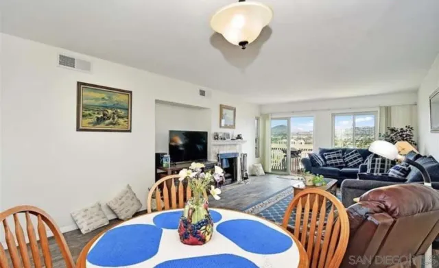 a living room with furniture kitchen view and a flat screen tv