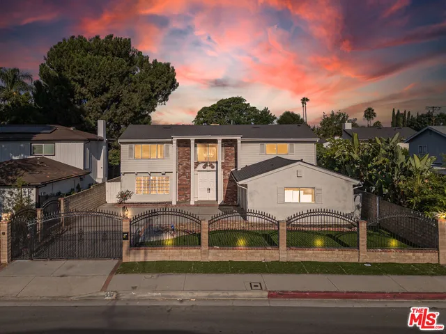 a front view of house with yard and mountain view in back
