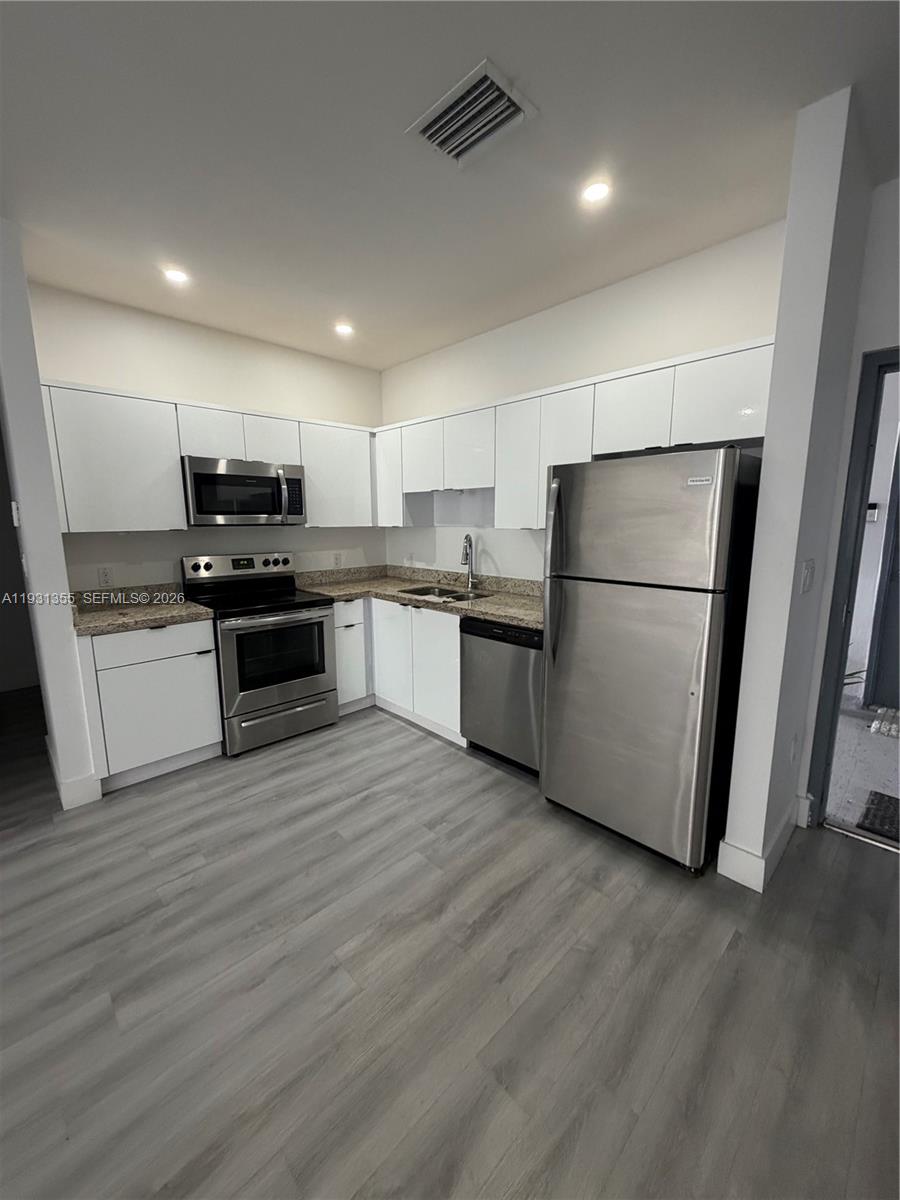 853 East 24th Street, Unit 305 Hialeah, FL 33013 - Photo 3 of 20 a kitchen with stainless steel appliances a refrigerator sink and microwave