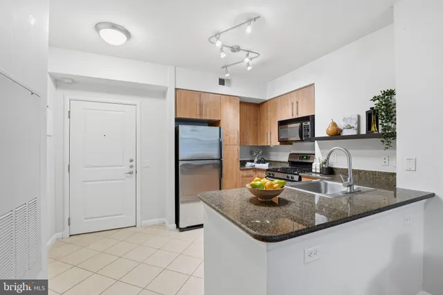 a kitchen with stainless steel appliances granite countertop a sink refrigerator and microwave