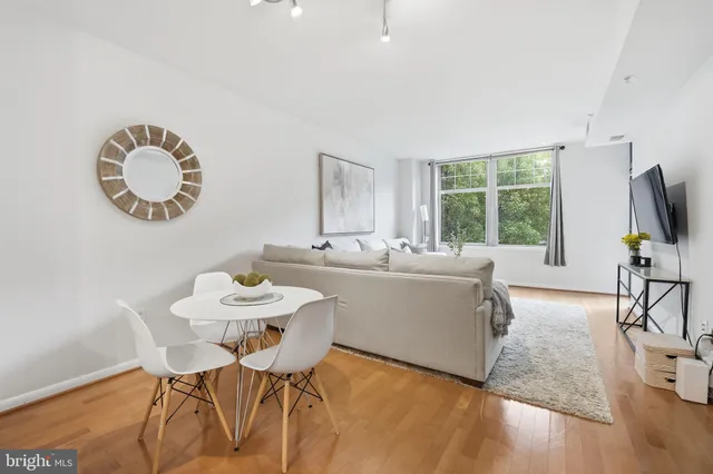 a view of a dining room with furniture a flat screen tv and wooden floor