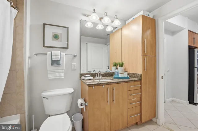 a bathroom with a granite countertop toilet sink and mirror