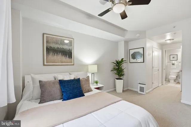 a bedroom with a large bed and a chandelier