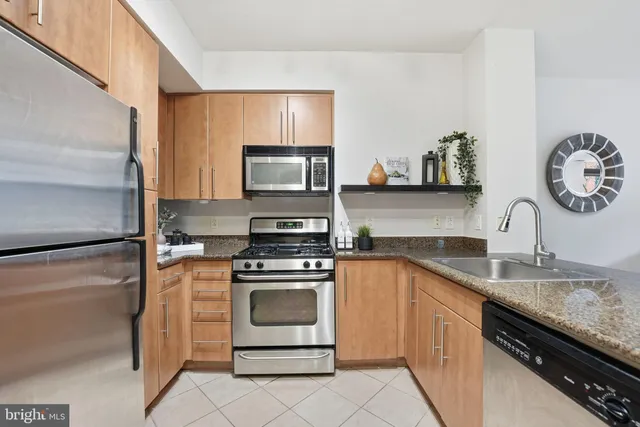 a kitchen with granite countertop a sink stove and refrigerator
