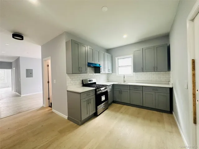 a kitchen with granite countertop a stove top oven sink and cabinets