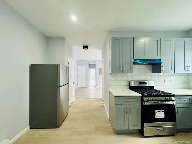 a kitchen with stainless steel appliances granite countertop a refrigerator and a stove