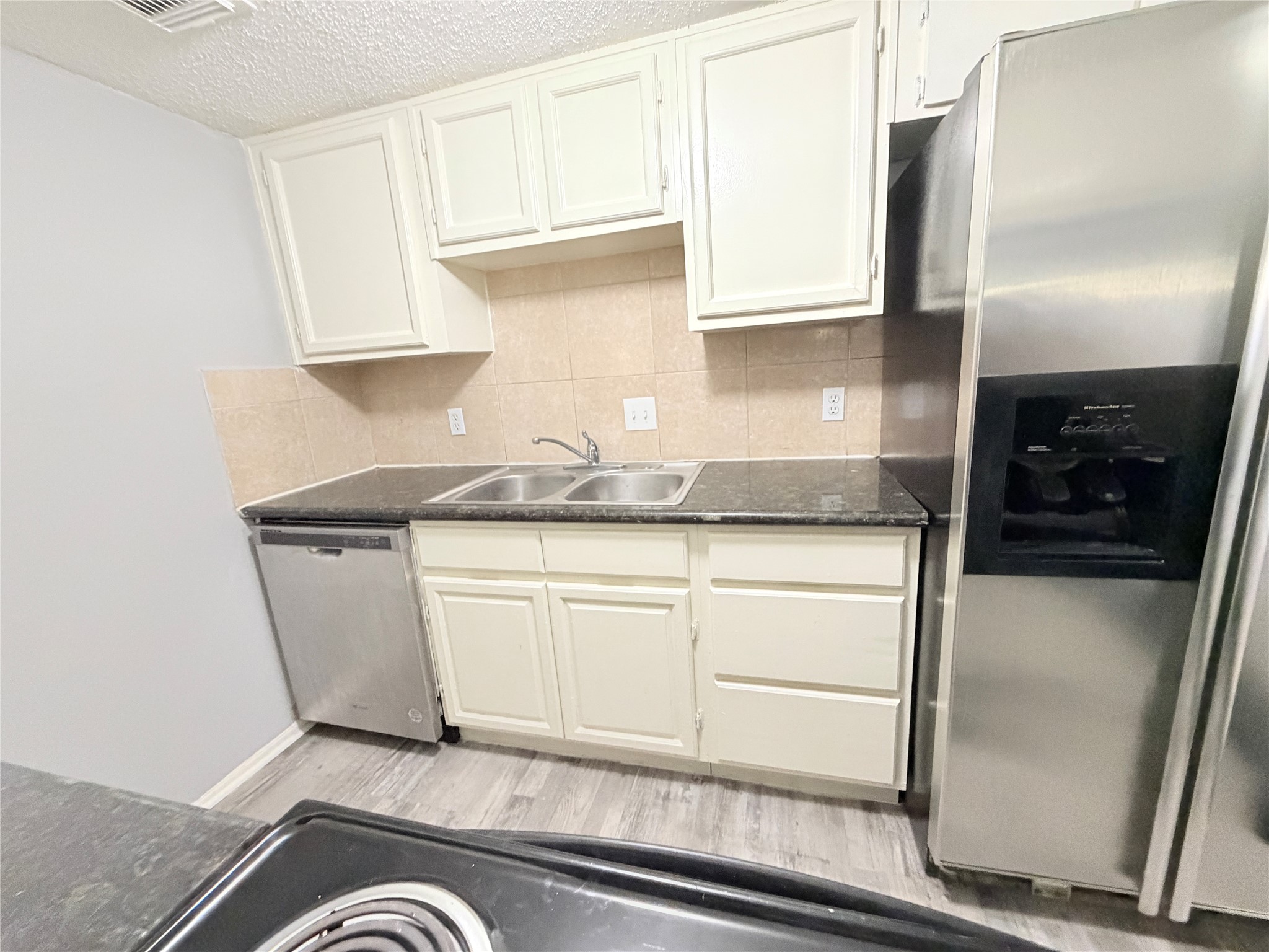 9461 Pagewood Lane, Unit 9461 Houston, TX 77063 - Photo 12 of 33 a kitchen with granite countertop white cabinets and refrigerator