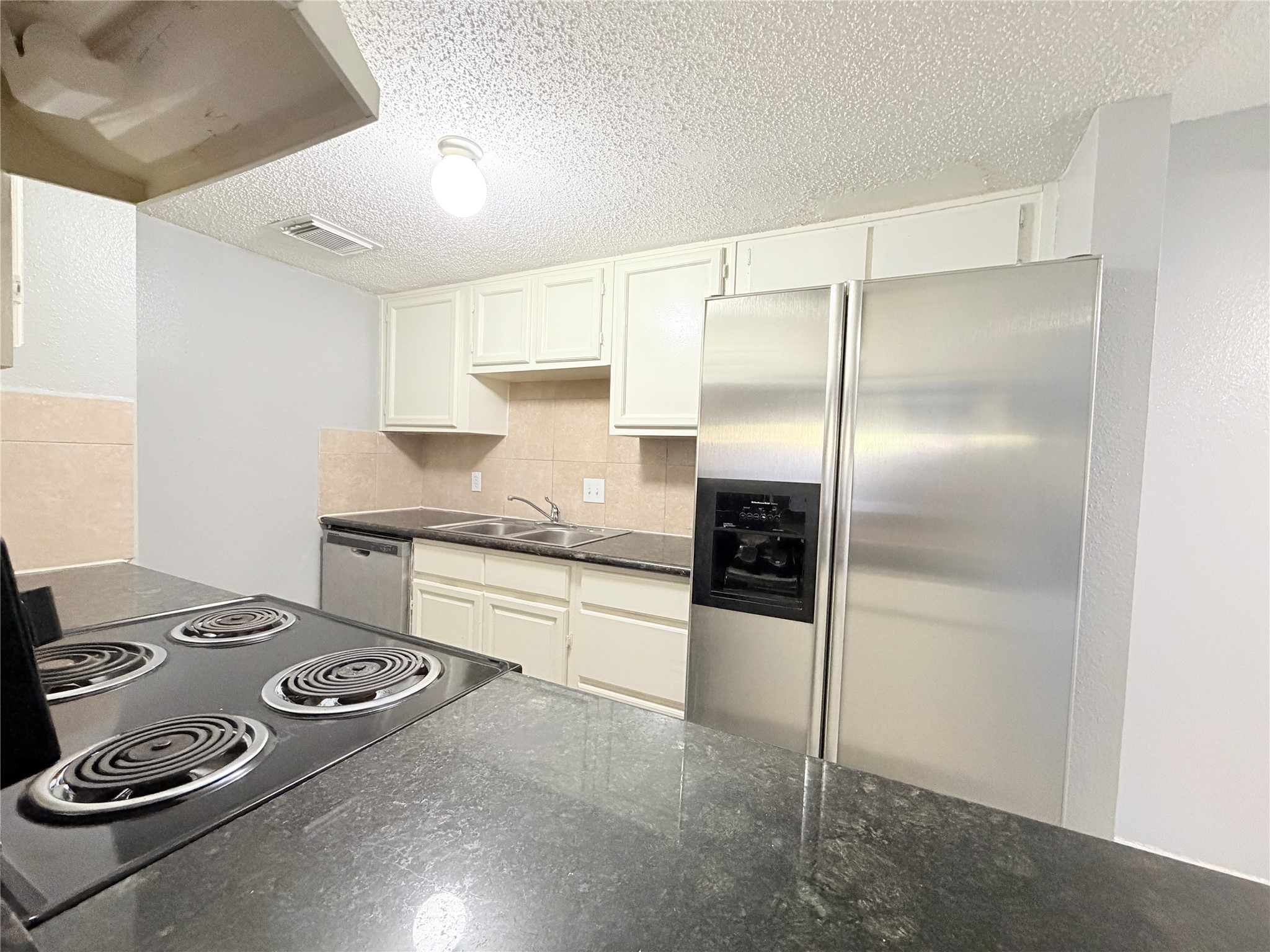 9461 Pagewood Lane, Unit 9461 Houston, TX 77063 - Photo 13 of 33 a kitchen with stainless steel appliances granite countertop a refrigerator and a stove