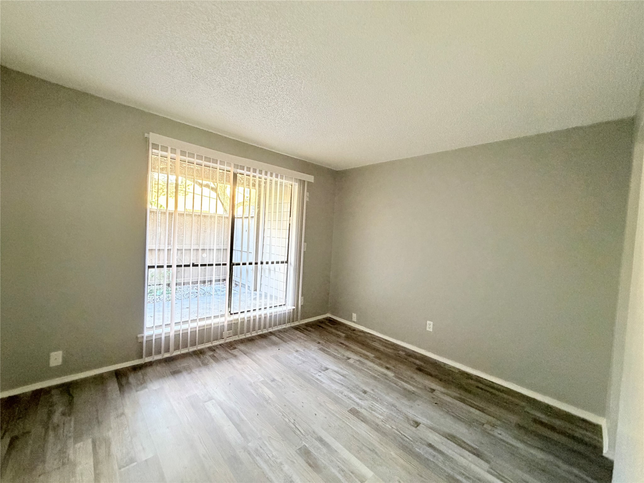 9461 Pagewood Lane, Unit 9461 Houston, TX 77063 - Photo 15 of 33 an empty room with wooden floor and windows