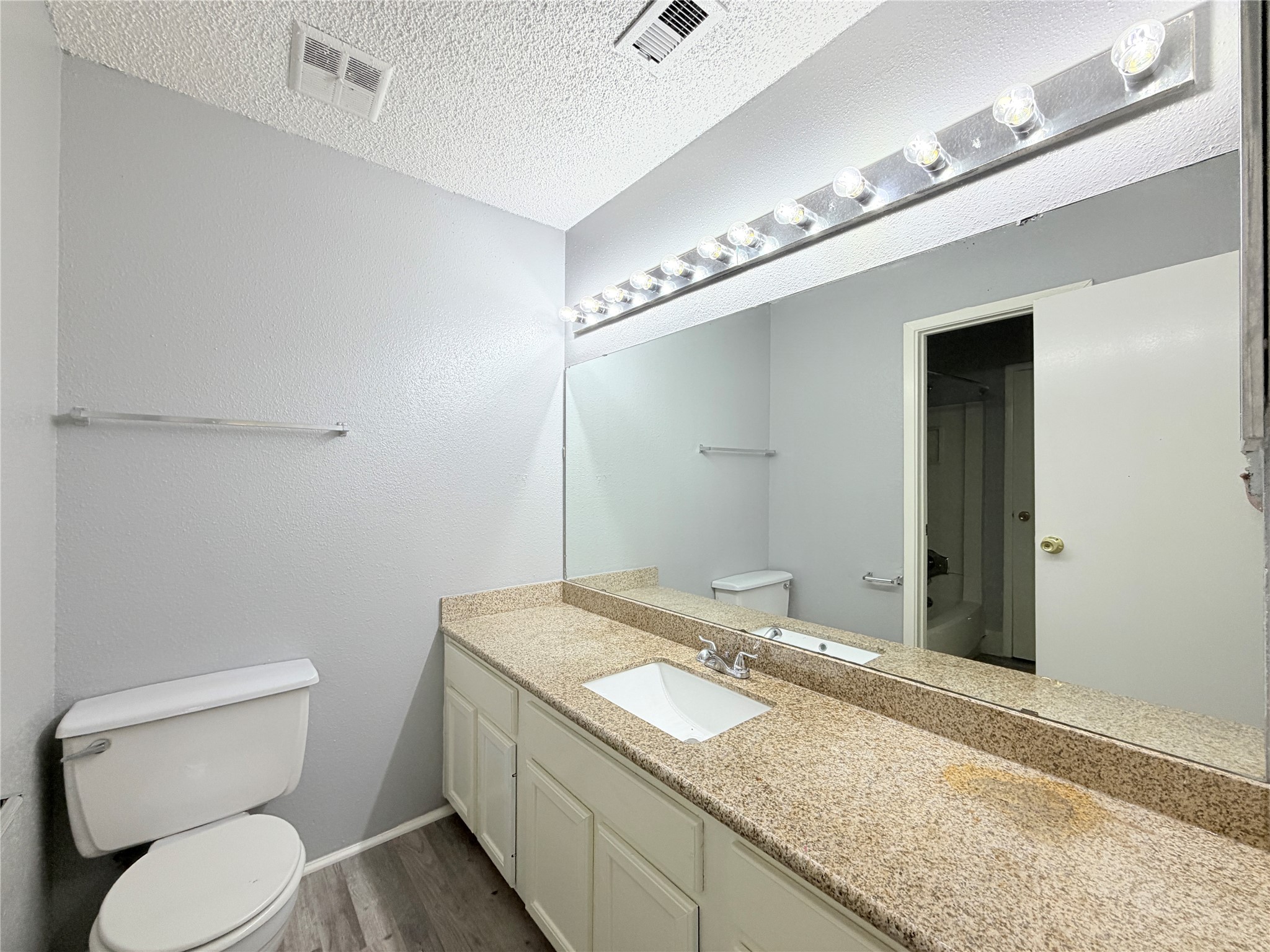 9461 Pagewood Lane, Unit 9461 Houston, TX 77063 - Photo 25 of 33 a bathroom with a granite countertop sink a toilet and a mirror