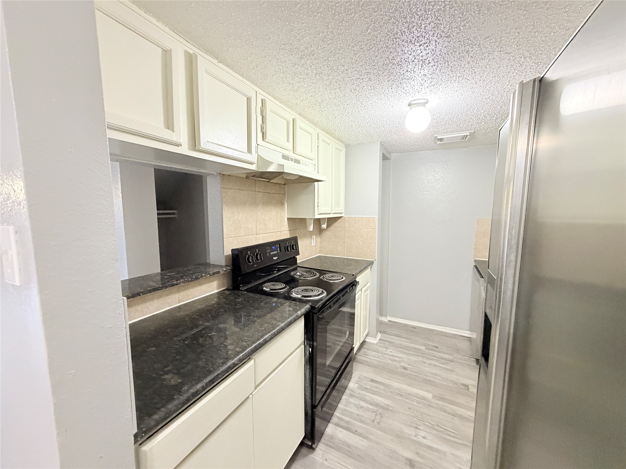 9461 Pagewood Lane, Unit 9461 Houston, TX 77063 - Photo 9 of 33 a kitchen with stainless steel appliances granite countertop a stove and a refrigerator