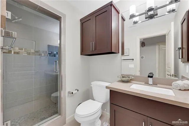 a bathroom with a sink a toilet and shower
