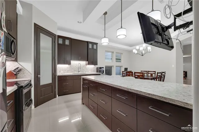 a kitchen with a sink dishwasher and a refrigerator with wooden floor