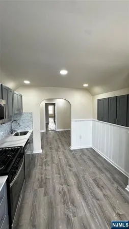 a view of a kitchen with a sink and wooden floor