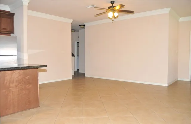 an empty room with a window and a ceiling fan
