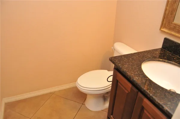 a bathroom with a granite countertop toilet and a sink