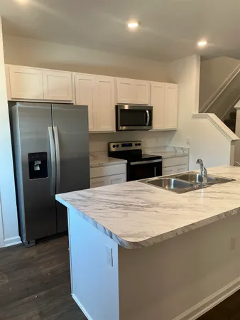 a kitchen with stainless steel appliances wooden cabinets a refrigerator and a sink