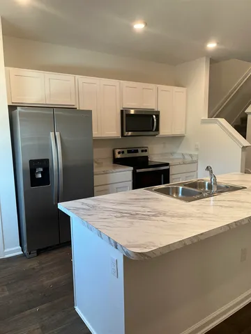 a kitchen with stainless steel appliances wooden cabinets a refrigerator and a sink