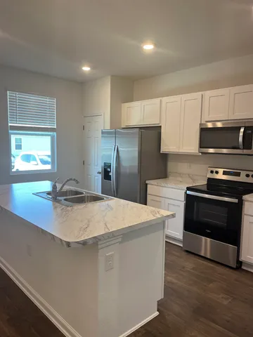 a kitchen with stainless steel appliances a refrigerator a stove a sink and a oven