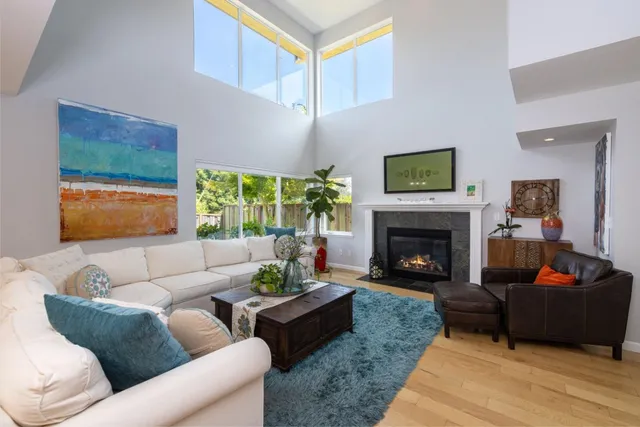 a living room with furniture a flat screen tv and a fireplace