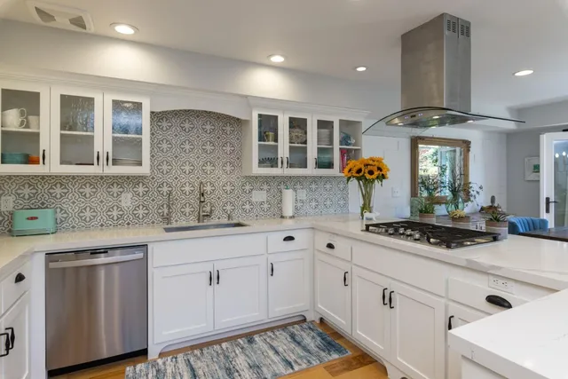 a kitchen with stainless steel appliances a sink stove and cabinets