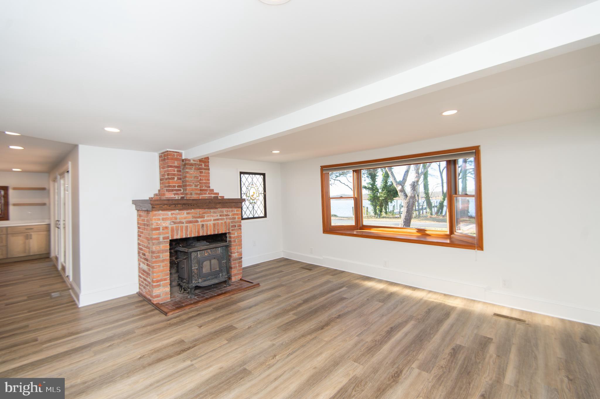11453 Riverton Road Mardela Springs, MD 21837 - Photo 21 of 71 an empty room with wooden floor fireplace and windows