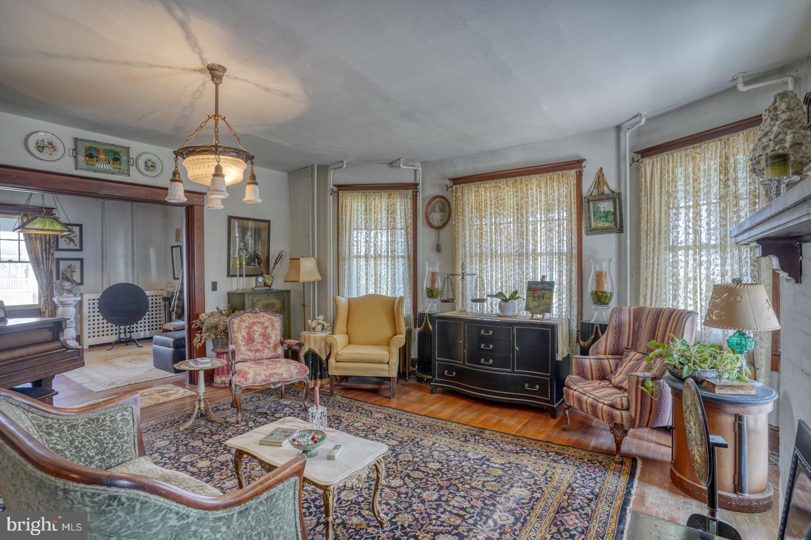 4096 Main Street Trappe, MD 21673 - Photo 23 of 70 a living room with furniture a dining table and a chandelier