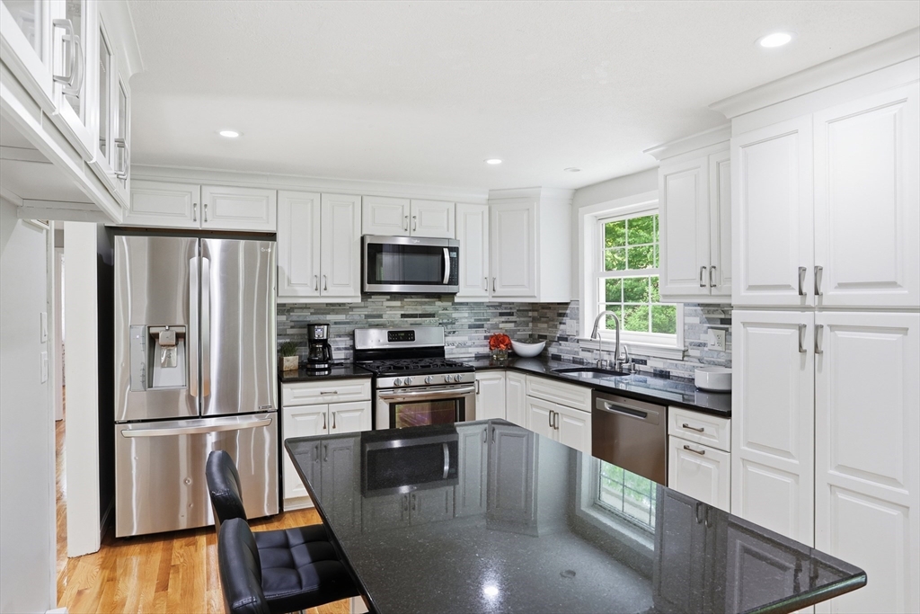 33 Simon Willard Road Acton, MA 01720 - Photo 7 of 42 a kitchen with kitchen island a counter top space a sink stainless steel appliances and cabinets
