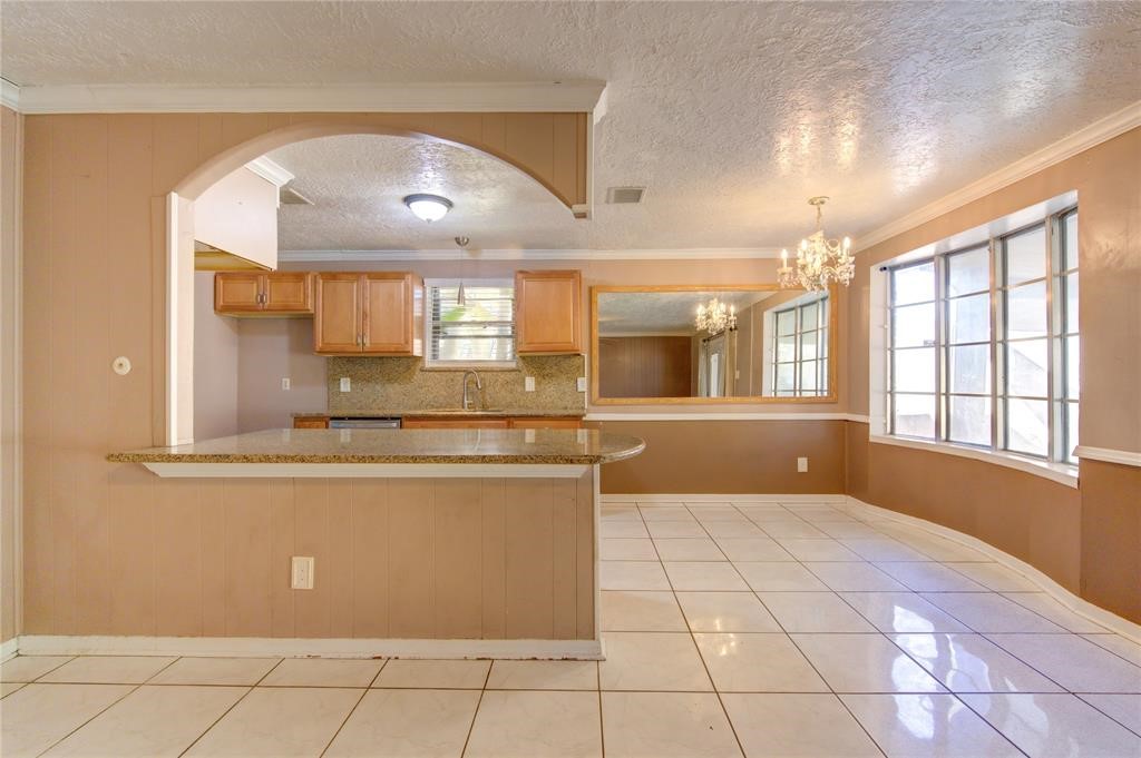 11222 Langdon Lane Houston, TX 77072 - Photo 9 of 20 a view of a kitchen with kitchen island granite countertop a refrigerator a sink a stove a dining table and chairs