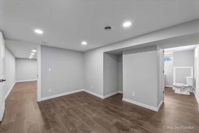 a view of a big room with wooden floor and a bathroom