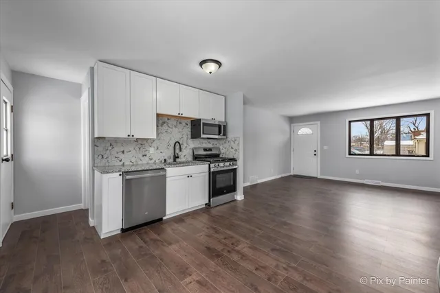 a kitchen with granite countertop white cabinets and white appliances
