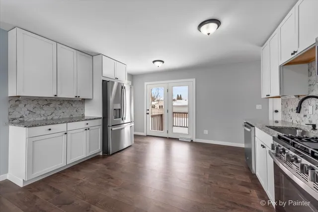 a kitchen with stainless steel appliances granite countertop a stove cabinets and wooden floor