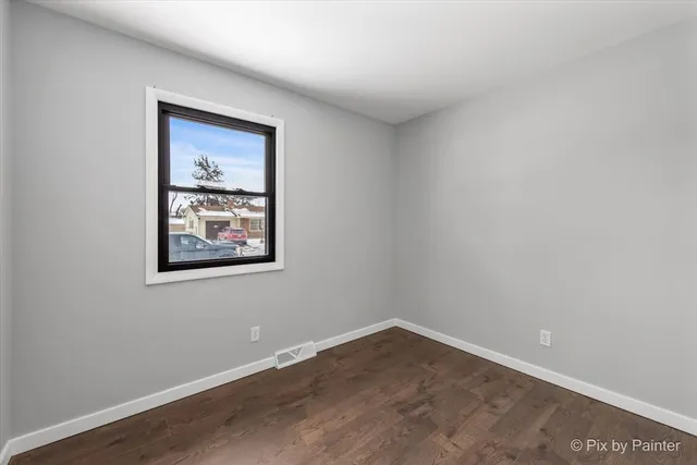 a view of a small space with wooden floor and a window