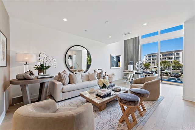 a living room with furniture a fireplace and a large window